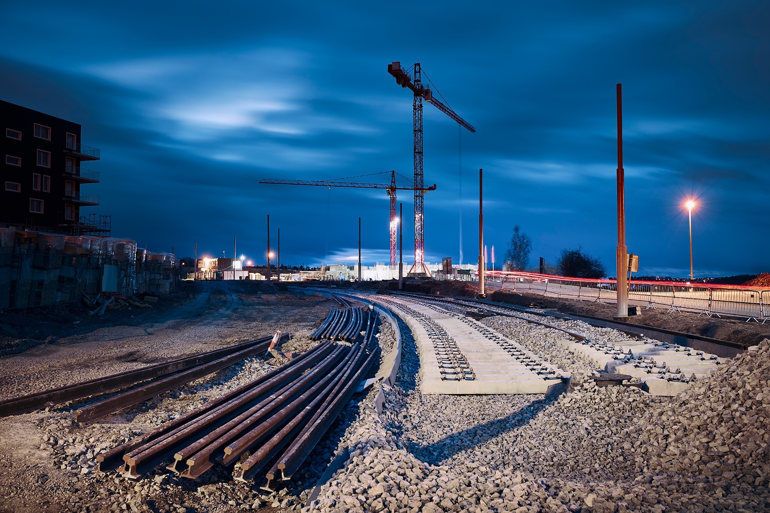 Anläggningsprojekt i skymning med spårbygge och krossat ballastmaterial